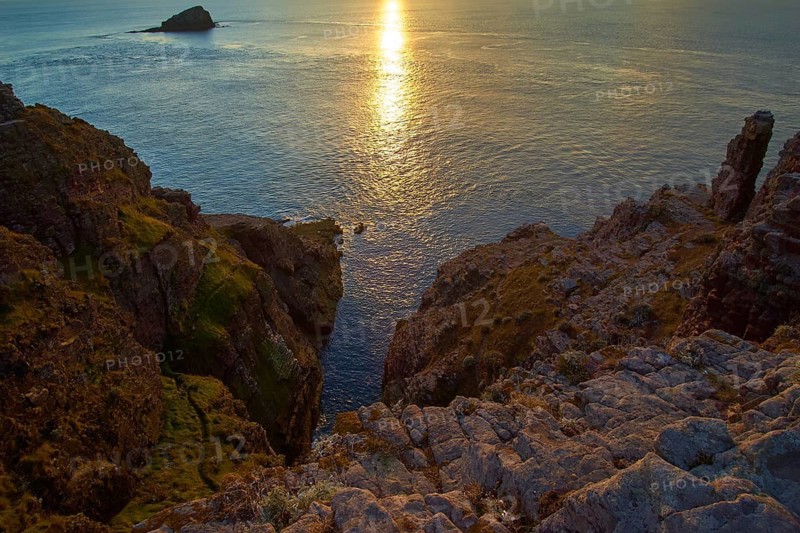 A tranquil sunset over the sea and rocky cliffs, Cap Frehel, Cotes-d Armor, Brittany, France