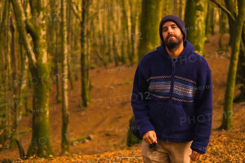 Lifestyle, a young man in a blue wool sweater enjoying the forest in autumn. Artikutza Forest in San Sebastián, Gipuzkoa, Basque Country. Spain