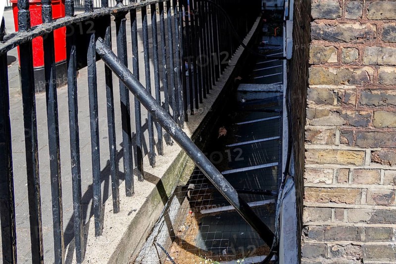 A Victorian penny chute set into the railings once let passers by donate coins to the House of Charity, London, England, United Kingdom