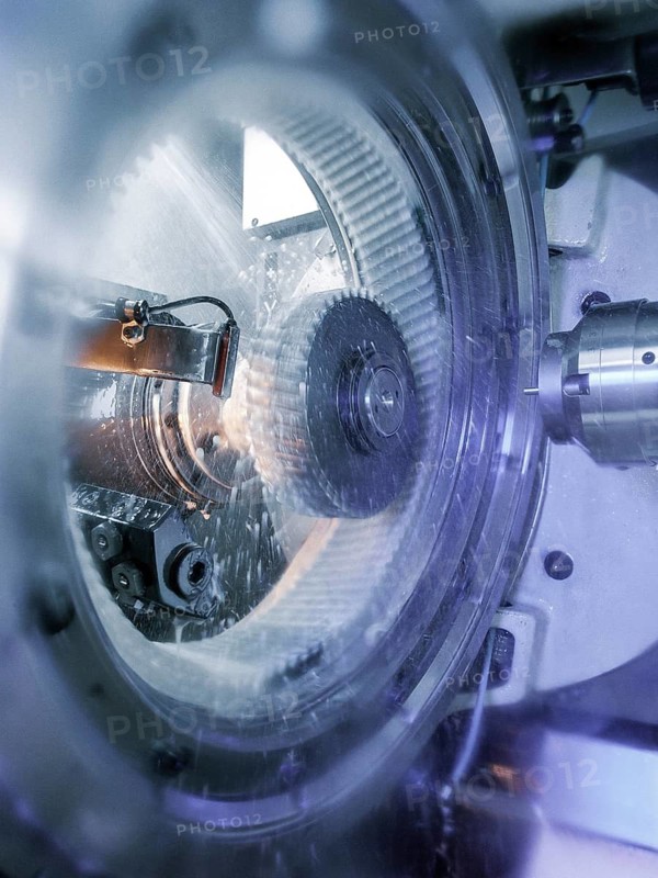 CNC controlled gear honing machine precisely finishing a metal gear with a honing tool during automated precision manufacturing and industrial production