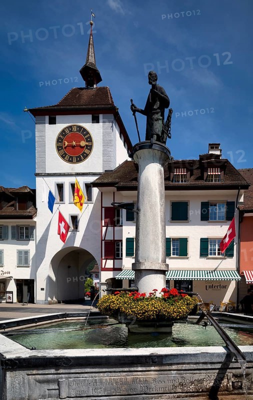 Lower gate, church patron saint St Paul, by Lucerne sculptor Rolf Brem, flags, national flag, Willisau, Canton Lucerne, Switzerland
