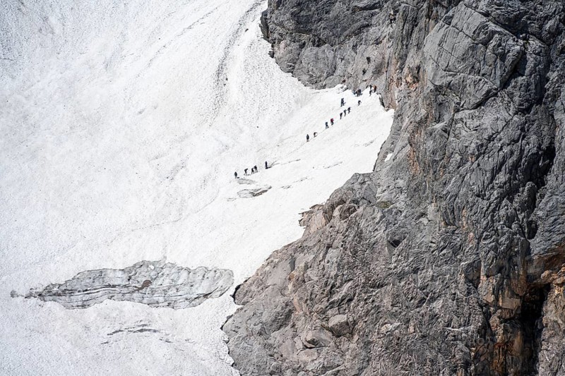 Mountaineers queuing at the transition from the Höllentalferner to the Zugspitz via ferrata, on a snowfield, overtourism, mountain basin with glacier remnant of the Höllentalferner, Höllental, rocky mountain peaks, Höllental, Bavaria, Germany