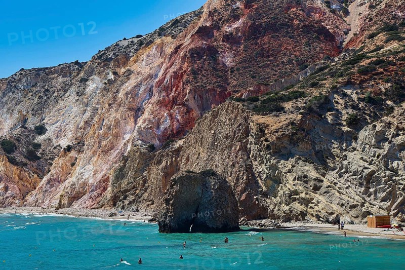 Beach, volcanic rocks, cliffs and sea with people swimming on a warm sunny day, Trypiti, Tripiti, village, Milos, island, Cyclades, Greek islands, Greece