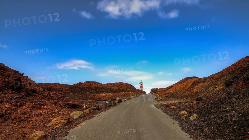 Punta de Teno, Lonely road leads to a lighthouse through red rocks under blue sky, Masca, Barranco de Masca, canyon, Teno, Teno Mountains, northwestern Tenerife, Tenerife, Canary Islands, Spain