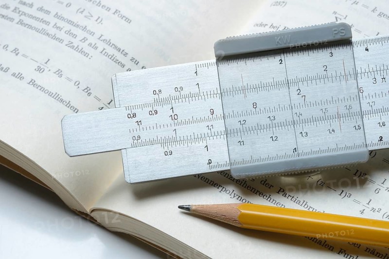 Slide rule on book, calculating aid