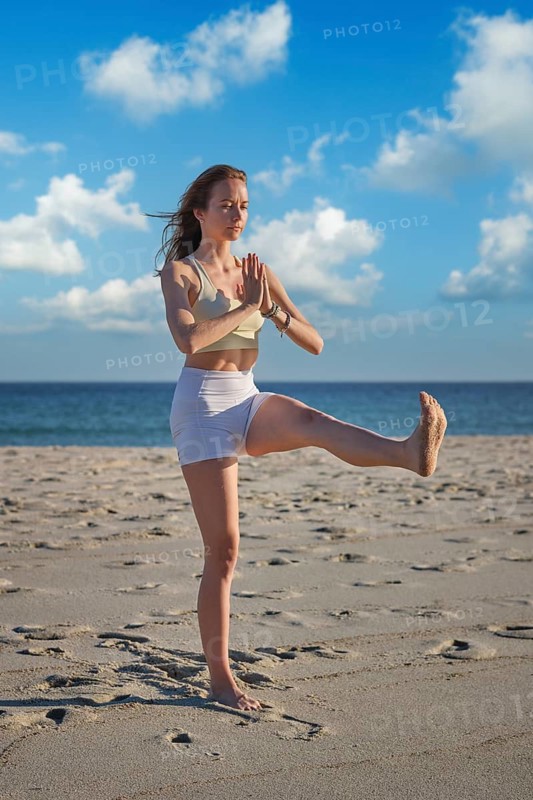 Scene featuring a woman, yoga, utthita hasta padangusthasana, hand toe pose, standing balance, prayer hands, and one leg balance