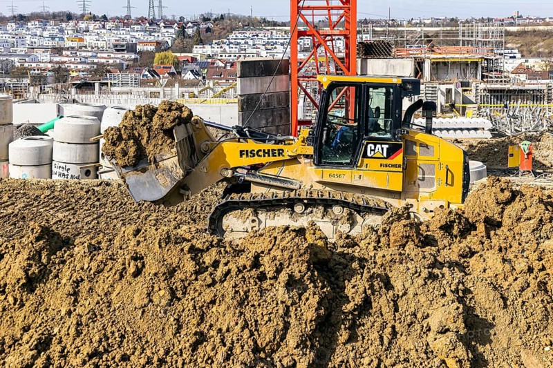 Construction site of the Böckinger Strasse neighbourhood in Zuffenhausen with bulldozer. A total of around 460 new flats for various user groups are being built here. A project of the International Building Exhibition 2027 (IBA'27) . Stuttgart, Baden-Württemberg, Germany