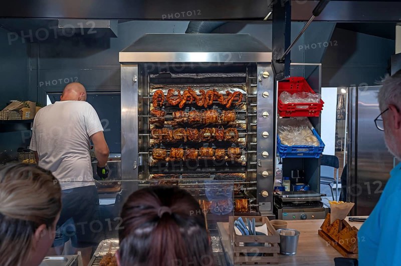 Oven with grilled meat on skewers in a stand at the city festival, customers waiting in front, Lauf an der Pegnitz, Middle Franconia, Bavaria, Germany