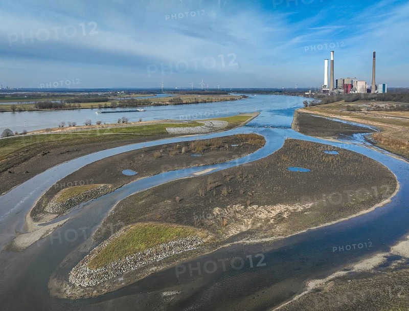 Dinslaken, Voerde, North Rhine-Westphalia, Germany - New Emscher estuary into the Rhine. Renaturalisation of the Emscher. Flood protection through land expansion. The decommissioned STEAG Voerde coal-fired power station in the background. The mouth of the Emscher into the Rhine was moved almost 500 metres north from Dinslaken to Voerde. Fish can now swim barrier-free up the new Emscher from the Rhine through a newly created floodplain area. Following the construction of a parallel sewer, the Emscher has been completely free of sewage since January 2022. The river was previously an open, above-ground combined sewer with rainwater and wastewater