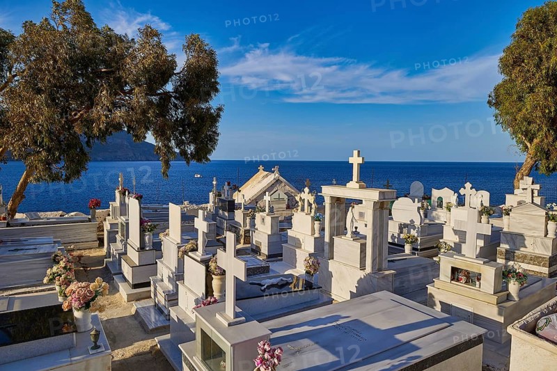 A cemetery with graves and crosses, overlooking the sea on a calm day, Agios Nikolaos church, cemetery, Pigadia, town and harbour, Pigadia Bay, main town, Karpathos, Dodecanese, Greek Islands, Greece
