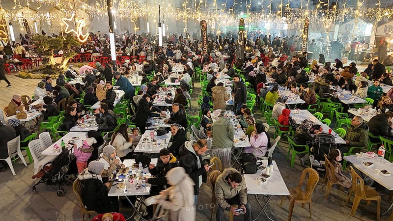 Aerial view captures hundreds of Muslims gathered at long tables for a communal Iftar meal in a festively decorated square outside a large mosque in Gaziantep, Turkey on March 11, 2026, Gaziantep, Turkey