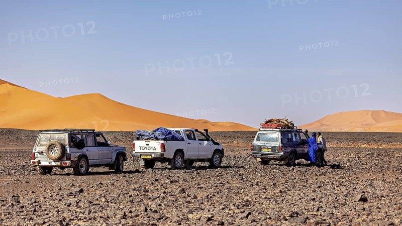 Three off-road vehicles parked together in the desert, people swapping stories, Off-road vehicles through the Sahara desert in Algeria