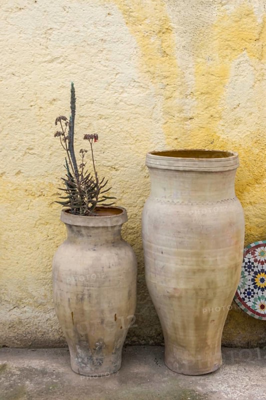 Amphorae as decoration in front of a yellow house facade, Meknes, Morocco