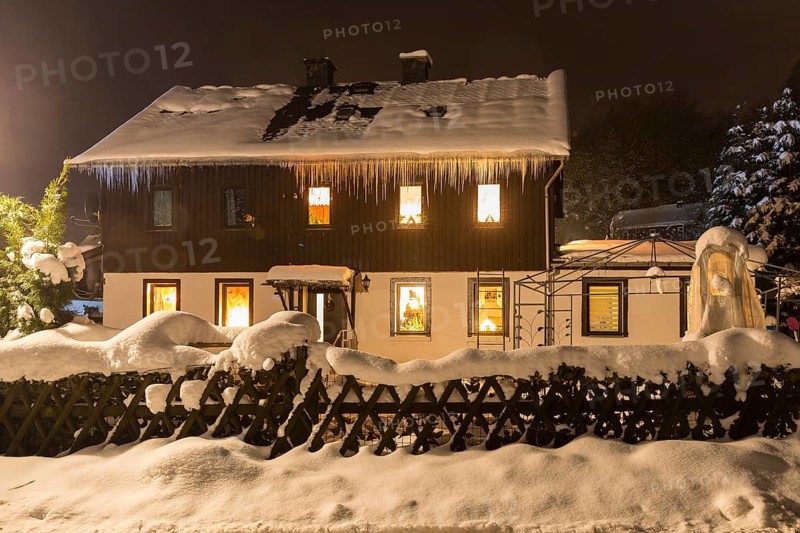 House with Christmas lighting in the snow, Oberlochmühle, Deutschneudorf, Erzgebirge, Saxony, Germany