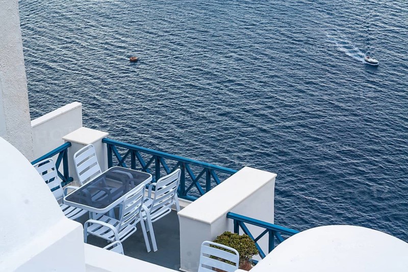 Santorini Greece Home Patio With Ocean View As Cruise Ship Tender Transports Tourists Below