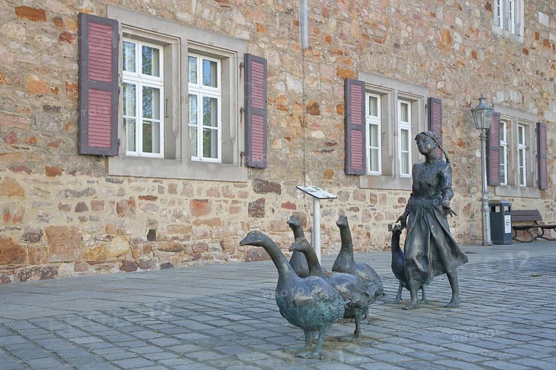 Gänseliesel sculpture by Markus Lüpertz 2000, modern art, bronze sculpture, sculpture group, life-size, woman with troop of goose figures, Melsungen, Hesse, Germany