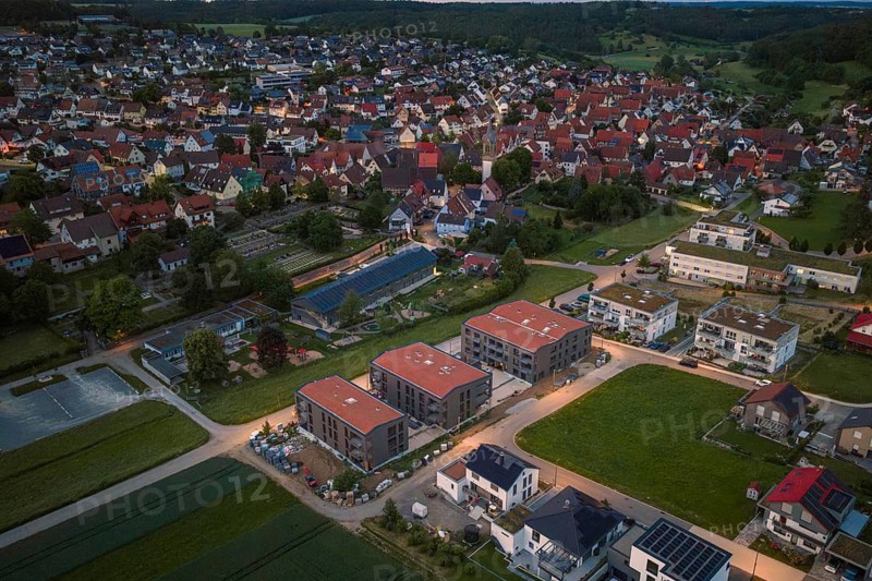 Aerial view of a city with a modern settlement in the foreground at dusk, Gechingen, Hecken and Gäu region, Landreis Calw, Germany