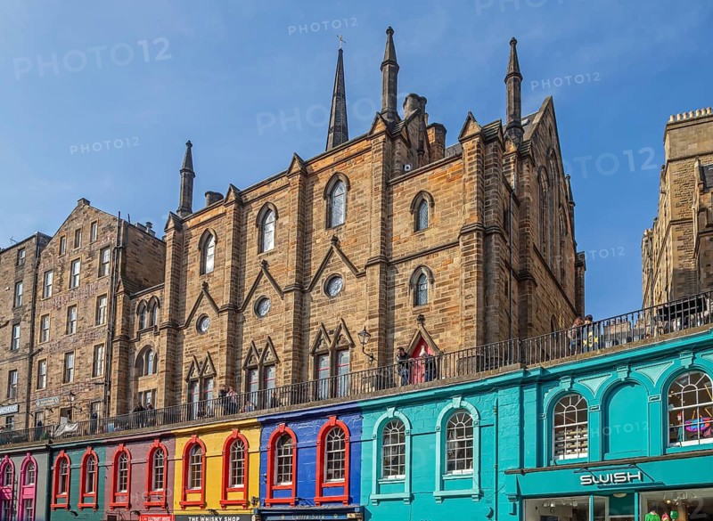 Victoria Street with colourful shops and St. Columba's Free Church of Scotland in the historic Old Town of the city Edinburgh, Scotland, UK