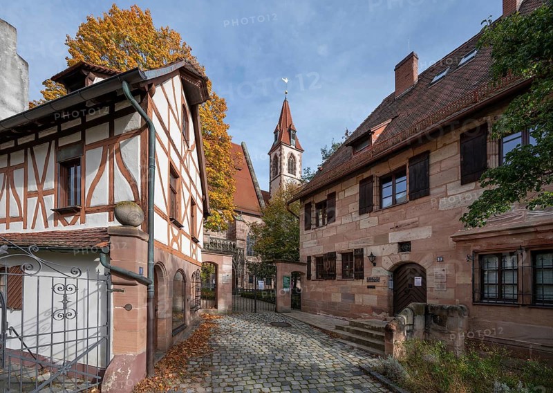 On the left an outbuilding of the Haller castle, already mentioned around 1200, behind the church of St Nicholas and St Peter, on the right the vicarage, Kirchenberg 11 and 13, Nuremberg-Mögeldorf, Middle Franconia, Bavaria, Germany