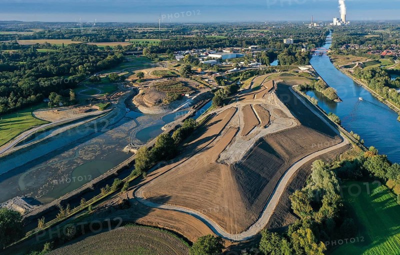 Recklinghausen, Castrop-Rauxel, North Rhine-Westphalia, Germany - EMSCHERLAND construction project, a 37-hectare water and nature discovery park at the water crossroads of the Rhine-Herne Canal and the renaturalised Emscher on the city boundary of Recklinghausen and Castrop-Rauxel. The ecological focal point at the confluence of Suderwicher Bach and Emscher will also be a future garden for the International Garden Exhibition 2027. Before the renaturalisation, the Emscher river system was an open, above-ground wastewater canal, combined sewer with surface water and wastewater. The Uniper power plant Datteln 4 in the background