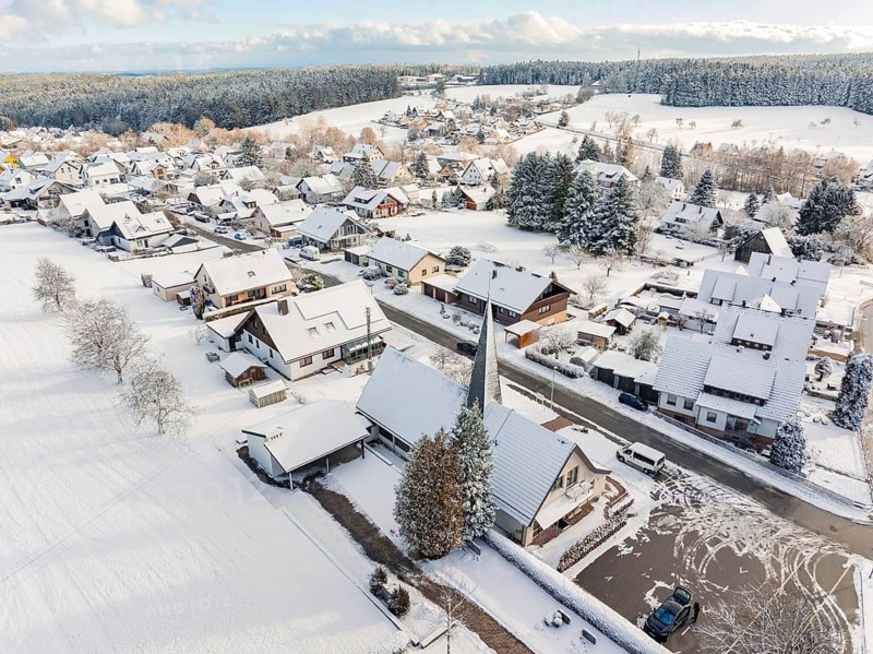 Snow-covered houses with church and streets in a small village, Oberreichenbach, Black Forest, district of Calw, Germany