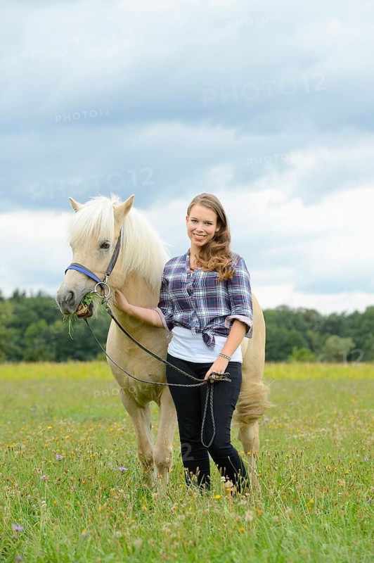 Young woman with a Icelandic horse on a meadow, Germany