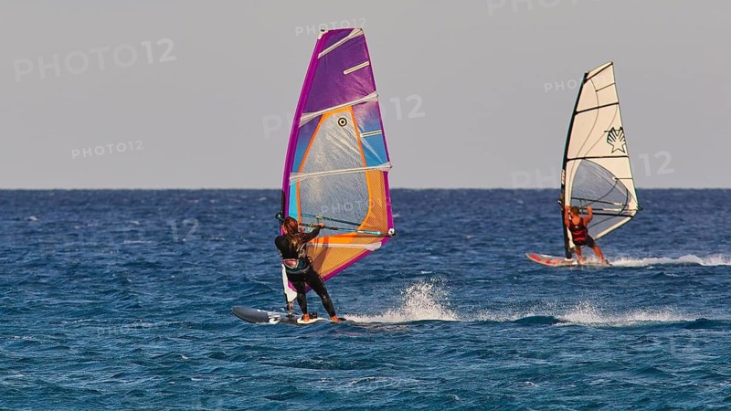 Two windsurfers competing on the water, windsurfers, Meltemi windsurfing area, Devils Bay, Paralia Vatha, Vatha Beach, south-east coast, Karpathos, Dodecanese, Greek Islands, Greece