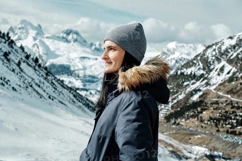 Woman in winter attire enjoying the scenic snowy landscape at Astun Ski Resort, nestled in the Huesca Pyrenees. Perfect setting for winter adventures