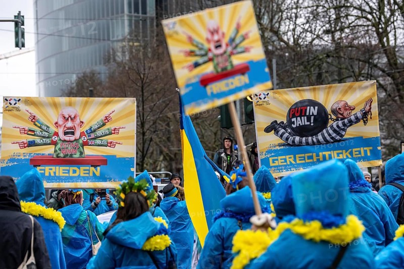 Members of the Blau-Gelbes Kreuz association, German-Ukrainian Association e.V., as a foot group at the Düsseldorf Rose Monday procession, show pictures with motifs from previous carnival motifs by the wagon manufacturer Jacques Tilly, who denounces Russia's war against Ukraine, a criminal case is therefore being brought against him in Russia, expression of solidarity for Tilly, North Rhine-Westphalia, Germany