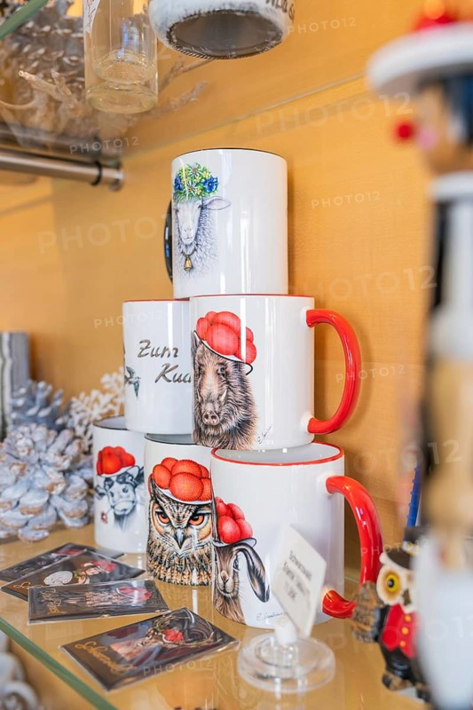 Shelf with mugs in Black Forest motif, wild animal designs such as owl and wild boar as souvenirs, Calw tourist information centre, Black Forest, Germany