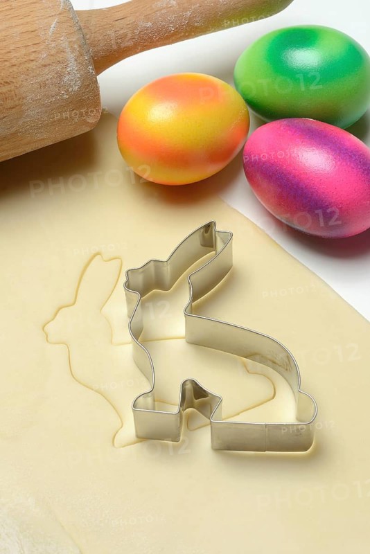 Rolled dough with bunny cookie cutter, rolling pin and Easter eggs