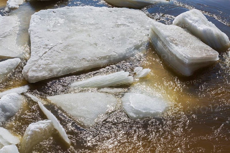 Close-up of large blocks of thick jagged ice floes floating on the surface of the Mille-Iles river during warm weather in late winter, Old Terrebonne, Quebec, Canada