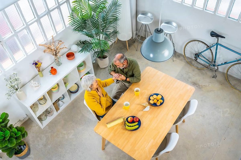 Top view full length photo of senior couple enjoying eating breakfast together at home