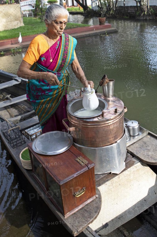 Tealady, 83 years old, making Indian tea on her boat, Backwaters, Kumarakom, Kerala, India