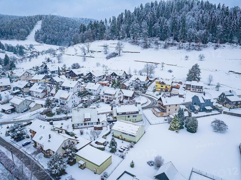 Village in a snowy landscape with wooded hills in the background, Enzklösterle, district of Calw, Black Forest, Germany