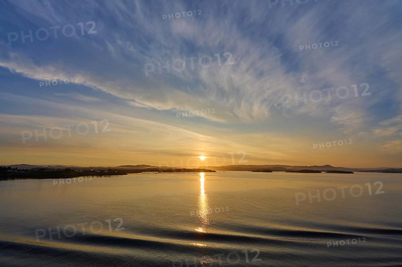 Calm seascape at sunrise with soft clouds and island in the background, Bergen, Vestland, Norway