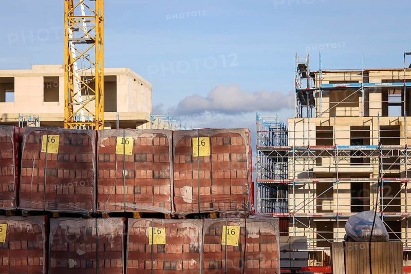 Bedburg, North Rhine-Westphalia, Germany, building material, clinker bricks packed on pallets, residential construction, new construction of multi-family residential buildings, new construction project, four-storey residential complex, one third of the flats are publicly subsidised, freely financed for rent and for purchase as condominiums