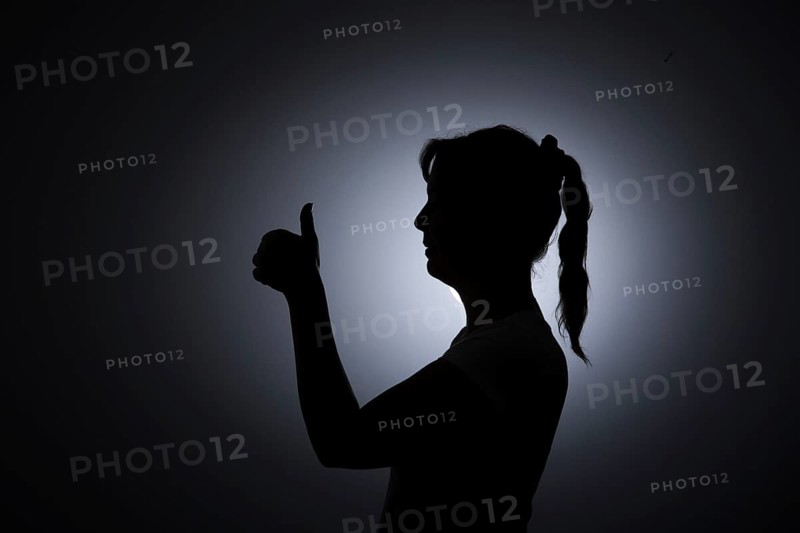 Symbol photo. Silhouette of a young woman giving a thumbs up. Berlin, 22.08.2024