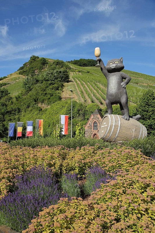 Roundabout with flags and sculpture black cat as a symbol of wine-growing region, wine glass, cheers, EU flag, German, French, Belgian, international national flags, Hessian state flag, Zeller Schwarze Katz, Zell, Untermosel, Moselle, Rhineland-Palatinate, Germany