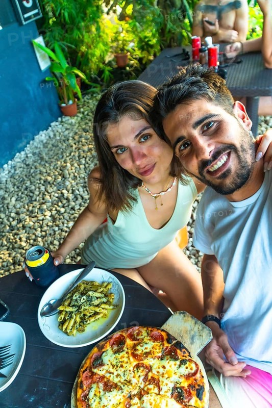 Tourists enjoying a delicious meal of pizza and pasta during their vacation in siargao island, philippines