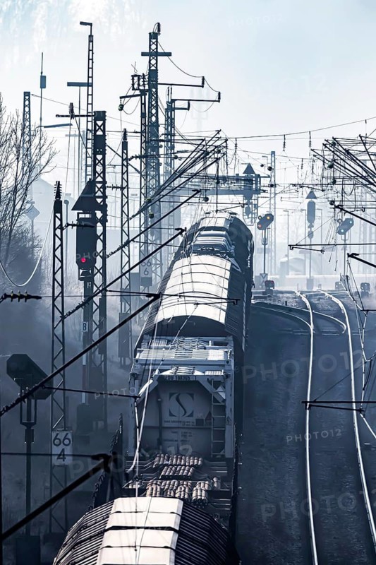 Deutsche Bahn AG tracks backlit with goods train. Overhead line, signals and infrastructure. Railway tracks at the Geislinger Steige, Alb ascent to the Swabian Alb. Amstetten, Baden-Württemberg, Germany