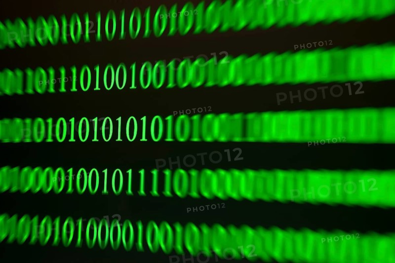 Green binary numbers displayed blurred, digital-technological atmosphere