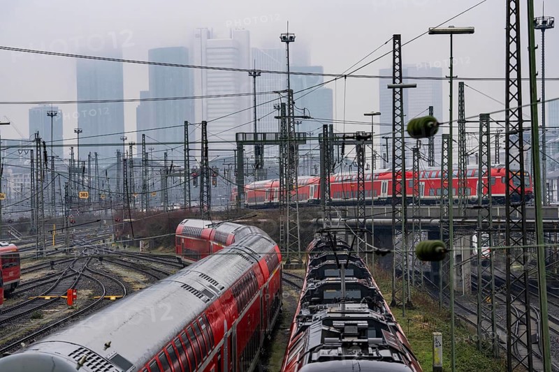 Railway tracks with regional trains, after freezing rain, in front of Frankfurt main station, skyline in the fog, Hesse, Germany
