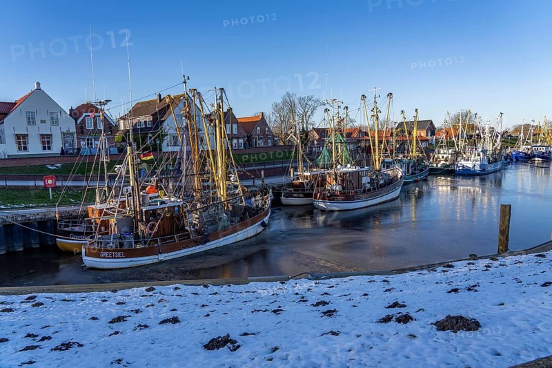 The fishing village of Greetsiel, historic fishing harbour, with the largest shrimp cutter fleet in East Frisia, historic houses, winter, partly frozen, in Lower Saxony, Germany