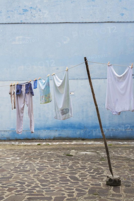 Washed clothes on clothesline in residential backyard with flagstones, Burano Island, Venetian Lagoon, Venice, Veneto, Italy