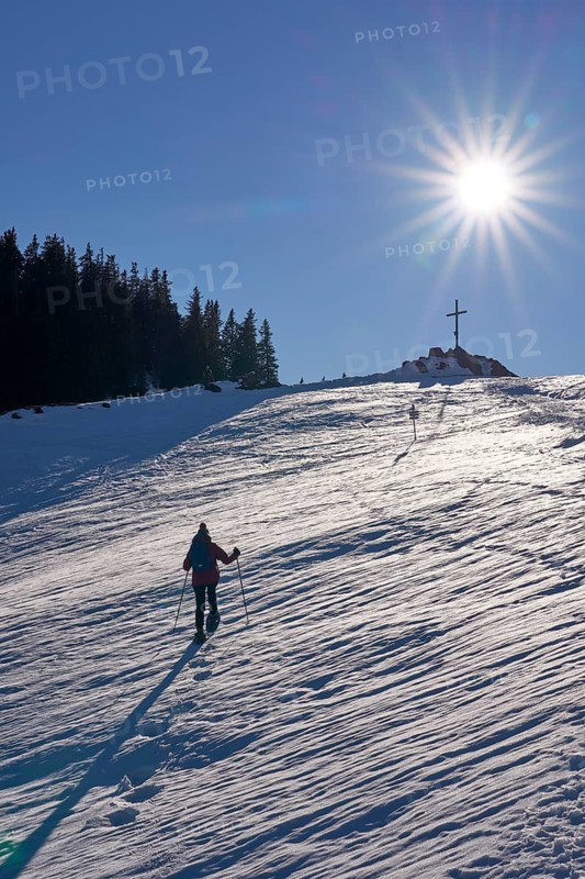 Nice and active senior woman snowshoeing in in the Allgau alps above Immenstadt, Bavaria, Germany