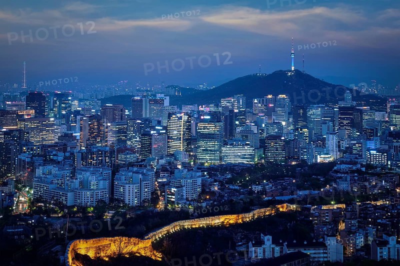 Seoul downtown cityscape illuminated with lights and Namsan Seoul Tower in the evening view from Inwang mountain. Seoul, South Korea