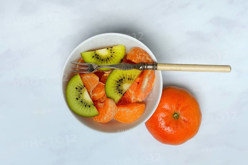 Clementine pieces and kiwi slices in peel