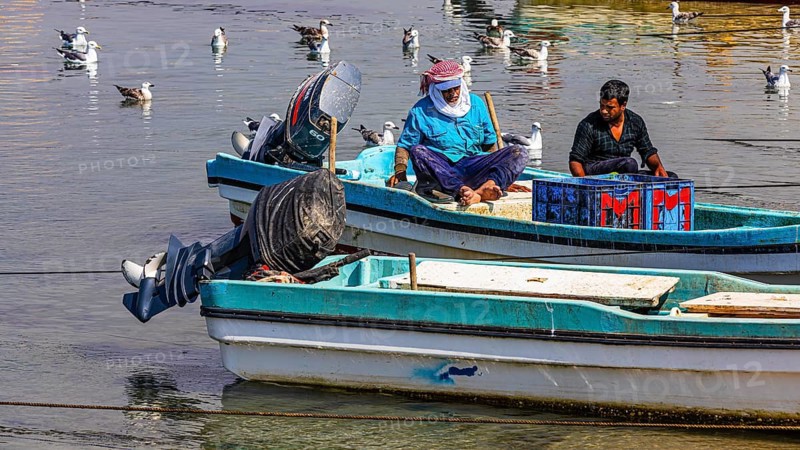 Fishermen working on their boats in the harbour of Mirbat, Dhofar Province, Arabian Peninsula, Sultanate of Oman