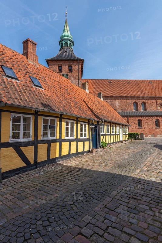 Svendborg Old Town, yellow, half-timbered house with St. Nicolai Church, cobblestones, entrance door, Fyn, Fyn Island, Denmark